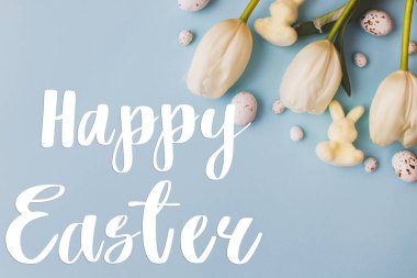 Mutlu Paskalya tebrik kartları. Mutlu Paskalya metinleri ve modern paskalya yumurtaları, laleler ve tavşanlar mavi arka planda yatıyordu. Mevsimlik tebrik kartı, el yazması mektuplar.