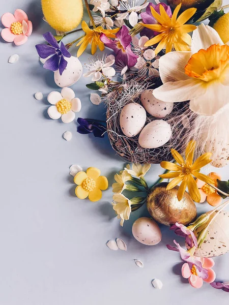 复活节快乐 鸟巢里有时尚的彩蛋 蓝色背景上有春天五彩缤纷的花朵组成 平铺着文字的空间 季节的贺卡 垂直移动照片 — 图库照片