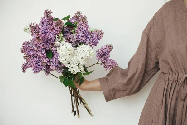 Mujer Elegante Sosteniendo Hermosas Flores Color Lila Contra Pared Blanca — Foto de Stock