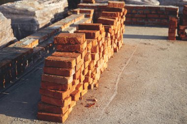 Beton temelde kırmızı tuğla yığını, ev inşa süreci. Döşemek için tuğlaları olan beton bir temel. İnşaat alanında inşaat malzemeleri