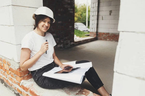 Stylish Happy Woman Engineer Hard Hat Looking Digital Plans Tablet — Stok fotoğraf