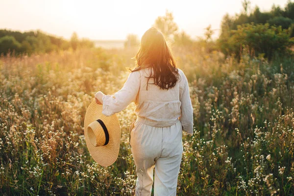 Stylische Boho Frau Mit Strohhut Die Zwischen Wildblumen Warmen Sonnenuntergang — Stockfoto