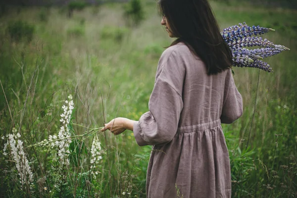 Kırsal Elbiseli Şık Bir Kadın Otlakta Lupin Buketi Topluyor Atmosferik — Stok fotoğraf