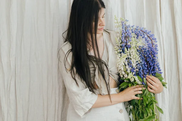Stylish Woman Holding Lupine Bouquet Rustic Room Young Female Linen — Foto de Stock