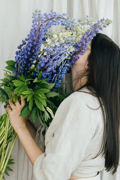 Stylish Woman Hiding Face Lupine Bouquet Rustic Room Close Gathering — Stockfoto