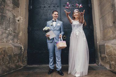 Mutlu gelin ve damat kutsal evlilikten sonra kilisenin arka planına şeker atıyor. Katedralde düğün töreni. Tatlı ile güzel duygusal evlilik çifti