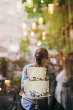 Lokantadaki düğün resepsiyonunun vitrininde lavantalı ve deve dikeni desenli lüks bir düğün pastası. Modern, güzel Provence düğün pastası. Ziyafetlerde lüks yemek servisi.