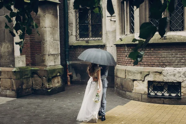 Stílusos Menyasszony Vőlegény Csók Ernyő Alatt Háttérben Régi Templom Esőben — Stock Fotó