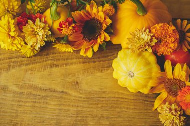 Stylish autumn composition. Colorful autumn flowers, pumpkins, pattypan squashes on rustic wooden table. Seasons greeting card template, space for text. Harvest in countryside. Happy Thanksgiving!
