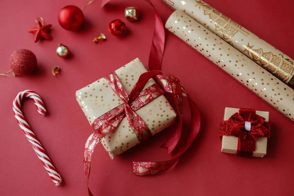 クリスマスの構図 赤い背景にスタイリッシュなクリスマスギフト 黄金の包装紙 リボンやお祝いの装飾 クリスマスプレゼントのコンセプトを包む ハッピー ホリデー — ストック写真