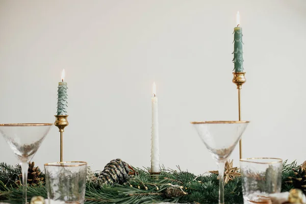 别致的圣诞餐桌布置 餐盘上有铃铛 老式餐具 有金光的冷杉枝条 桌上有蜡烛 大气假日早午餐 — 图库照片