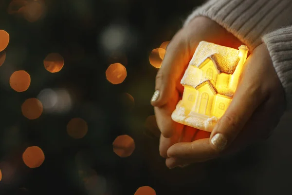 Kis Izzó Ház Kezében Háttérben Megvilágított Karácsonyfa Fények Bokeh Varázslatos Stock Fotó