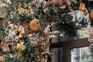 Balkabağı dekorasyonu. Dış binanın sonbahar dekoru çok şık. Balkabakları ve çiçek aranjmanı ve sokak dekorasyonu