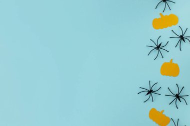 Cadılar Bayramı yatıyordu. Mavi arka planda siyah örümcekler ve sarı balkabağı süslemeleri. Mutlu Cadılar Bayramı! Metin için alanı olan yaratıcı kart şablonu. Modern minimal sınır