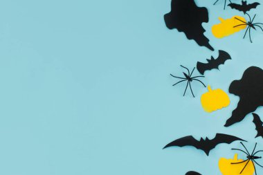 Cadılar Bayramı. Mavi arka planda siyah hayaletler, örümcekler, yarasalar ve sarı balkabağı süslemeleri yatıyordu. Mutlu Cadılar Bayramı! Metin için boşluk içeren kart şablonu. Modern minimal sınır