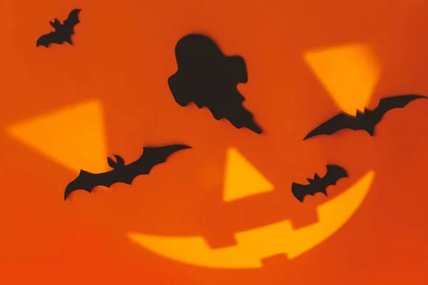 不気味なハロウィン オレンジの背景にジャック ランタンの顔を持つ黒い幽霊やコウモリの装飾 ハロウィン だましたり治療したり テキストの空間 — ストック写真
