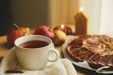 Sonbahar kızarıklığı hala hayattadır. Tarçınlı, mumlu, sonbahar yapraklı, balkabaklı ve fındıklı taze elmalı turta ile sade ahşap masada, şık bir fincanda ılık çay. Atmosferik konforlu ev