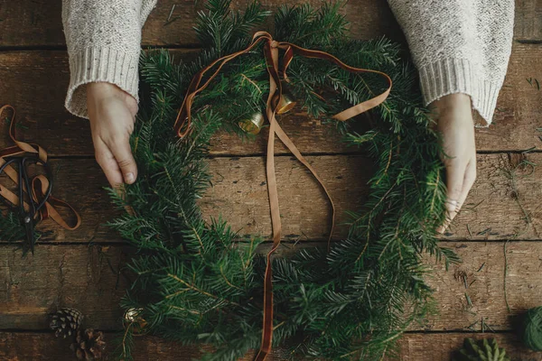 Manos Mujer Sosteniendo Elegante Corona Navidad Con Cinta Campanas Rústica — Foto de Stock