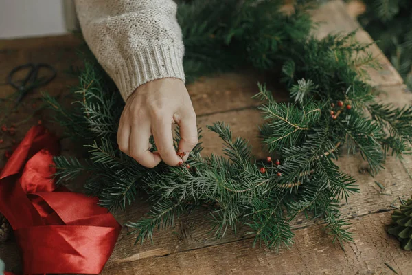 Fazendo Grinalda Natal Mãos Mulher Segurando Bagas Vermelhas Decorando Ramos — Fotografia de Stock