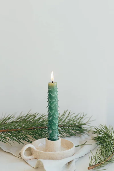 用冷杉枝条和亚麻布铺在白的乡村桌子上 像冷杉树一样 是别致的圣诞烛光 手工制作的现代绿色蜡烛 假期来了圣诞快乐及节日快乐 — 图库照片