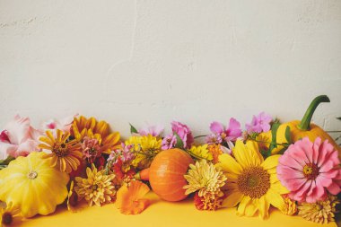 Mutlu Şükran Günleri Renkli sonbahar çiçekleri, balkabağı, kırsal arka planda sarı kağıt üzerinde patates kabağı olan şık bir sonbahar kompozisyonu. Metin için alanı olan mevsimlik tebrik kartı şablonu