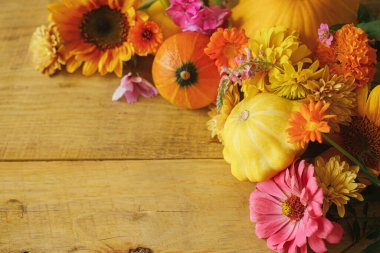Happy Thanksgiving! Stylish autumn composition on rustic background. Colorful autumn flowers, pumpkins, pattypan squashes on wooden table. Seasons greeting card, space for text. Hello Fall