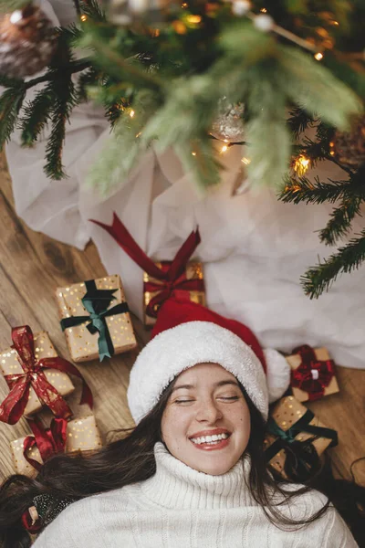 Happy Woman Santa Hat Lying Christmas Gifts Christmas Tree Top — Stock Photo, Image