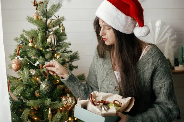 Stylish Woman Cozy Sweater Santa Hat Decorating Christmas Tree Atmospheric — Stock Photo, Image