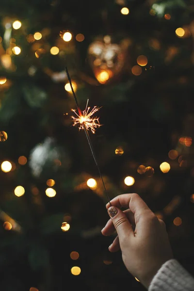 Brennende Wunderkerze Weiblicher Hand Auf Dem Hintergrund Der Weihnachtsbaumbeleuchtung Dunklen — Stockfoto