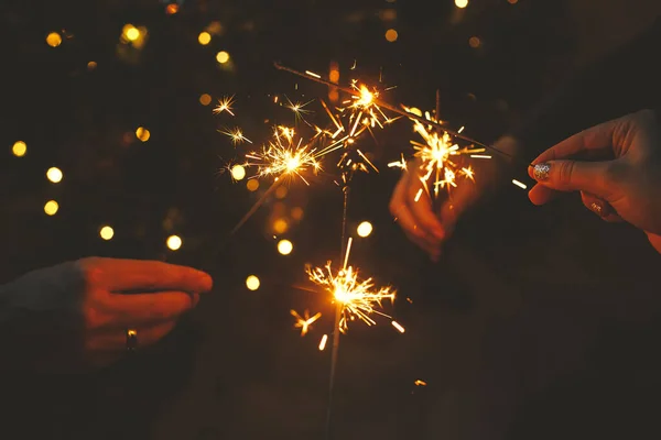 Feliz Año Nuevo Manos Sosteniendo Fuegos Artificiales Contra Las Luces — Foto de Stock