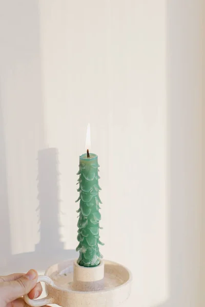 Hand Hält Stilvolle Weihnachtsbaumkerze Auf Sonnigem Weißen Hintergrund Zimmer Feierlicher — Stockfoto