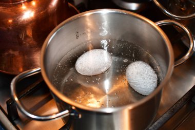 Tavuk yumurtası pişiriyorum. Yumurtalar metal bir tencerede kaynatılır. Sudaki hava kabarcıkları.