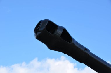 The barrel of the cannon is painted black. Barrel of a cannon against the blue sky.