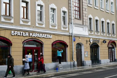 Sokak panoraması. KARAVAEV 'in Rus kardeşlerindeki şekerleme dükkanı yazıtları. İnsanlar mağazadan alışverişe gider. 11 Şubat 2022. Moskova, Rusya.