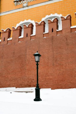 Kırmızı bir duvarın arka planında eski bir fener..