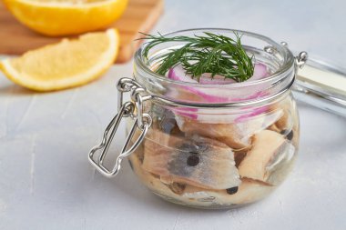 Cam kavanozda tuzlanmış ringa balığı filetosu.