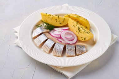 Kırmızı soğan tabağıyla dilimlenmiş salamura fileto balığı.