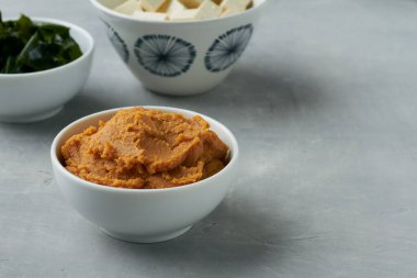 Miso paste shiro miso gri arka planda bir kasede soya çorbası ve soya soslu yosun.