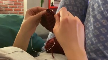 Kadın evde örgü örüyor. Yakından bak.