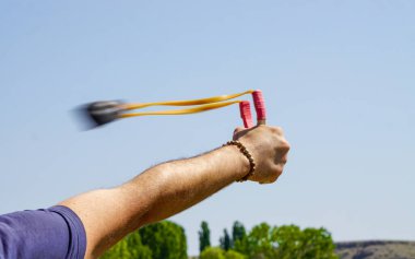 Man using spear thrower throwing rock nature amusement
