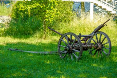 Vintage wooden carriage axle on green field