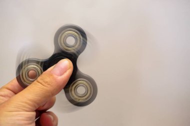 Fidget spinner turning in man hand with motion blur close up view