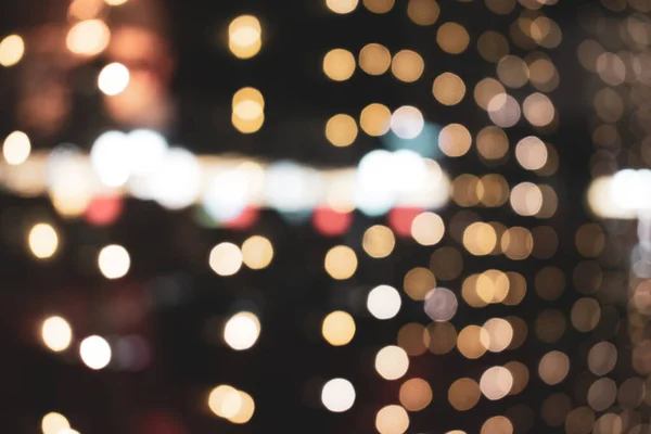 Noel ışıkları. Xmas. Yeni yıl kutlamaları altın ve siyah arkaplanı bulanıklaştırdı. Parlak arka plan, doku. Bokeh.