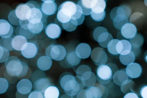 Noel ışıkları. Xmas. Yeni yıl kutlamaları mavi ve siyah arkaplanı bulanıklaştırdı. Parlak arka plan, doku. Bokeh.