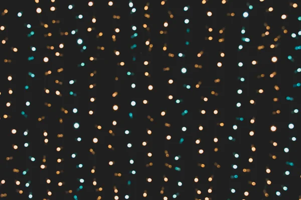 Vánoční světla. Vánoce. Slavnostní Nový rok rozmazané modré, zlaté a černé pozadí. Jiskřivé pozadí, textura. Bokeh. Stock Obrázky