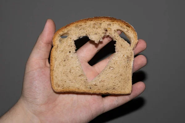 Ψωμί Σίκαλης Φέτα Ψωμιού Τρύπα Σχήμα Καρδιάς Γκρι Χέρι — Φωτογραφία Αρχείου