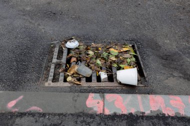 trash blocking storm drain gutter graffiti sidewalk