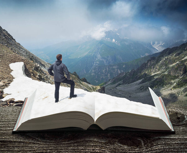 Hiker on a glacier in a Caucasus mountains on a pages of an open book. Travel and education concept.