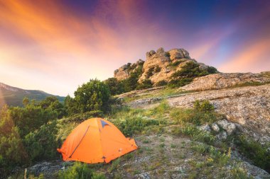 Gün doğumunda kayalık bir uçurumun kenarında kamp çadırında. Açık hava ve seyahat kavramı.
