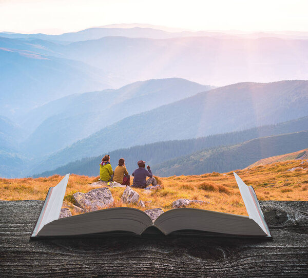 Group of hikers enjoy the valley on the pages of an open magical book. Majestic landscape. Travel and education concept.